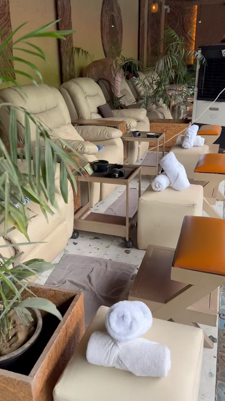 A row of cream recliners with rolled white towels waiting on each footrest